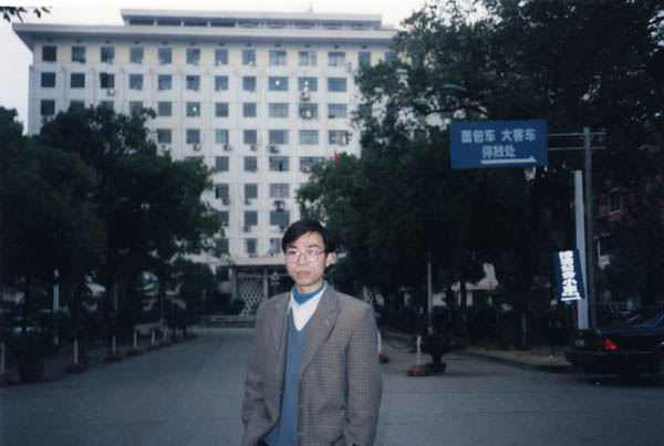 市政府大楼前，我们在8楼，那个时候我戴着一副很厚的眼镜